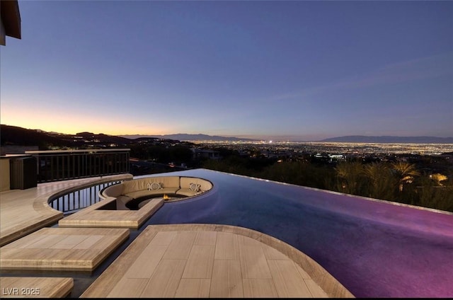 1228 Stellar Rim Ct, Henderson, NV 89012 - pool at dusk with a mountain view and an in-ground hot tub