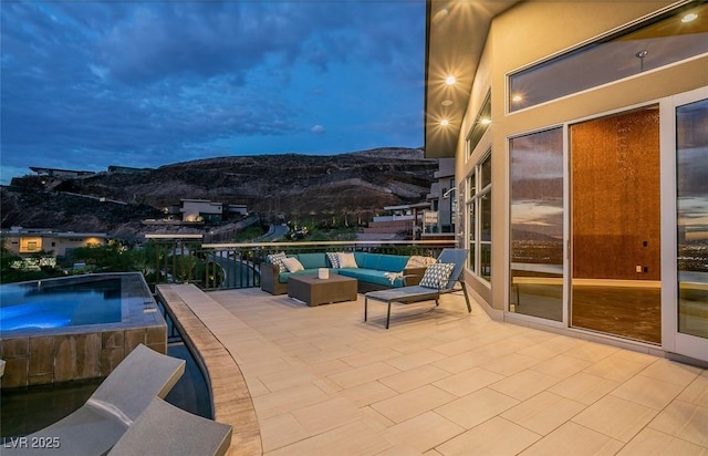 view of patio / terrace with an outdoor hot tub, a mountain view, and an outdoor hangout area