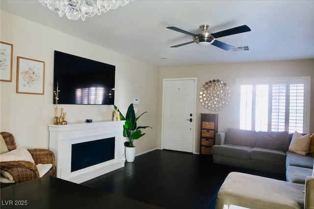 7257 Early Pioneer Ave, Las Vegas, NV 89129 - living room featuring dark wood-type flooring, ceiling fan, a chandelier, and a fireplace