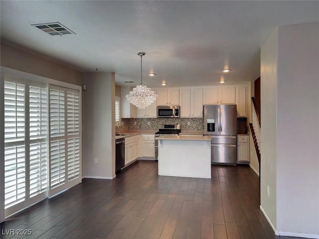 7257 Early Pioneer Ave, Las Vegas, NV 89129 - kitchen with stainless steel appliances, a chandelier, healthy amount of natural light, and decorative backsplash