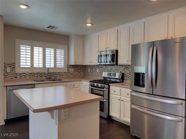 7257 Early Pioneer Ave, Las Vegas, NV 89129 - kitchen with stainless steel appliances, a sink, a kitchen island, decorative backsplash, and recessed lighting