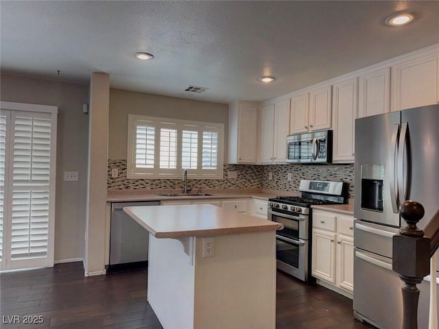 7257 Early Pioneer Ave, Las Vegas, NV 89129 - kitchen with appliances with stainless steel finishes, a sink, tasteful backsplash, light countertops, and a center island