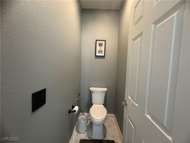 640 House Blend Ln, Henderson, NV 89052 - bathroom featuring baseboards, toilet, marble finish flooring, and a textured wall