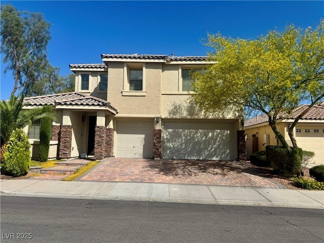 640 House Blend Ln, Henderson, NV 89052 - view of front facade featuring stucco siding, a garage, a tiled roof, decorative driveway, and stone siding