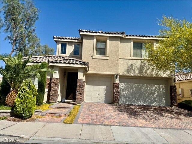 640 House Blend Ln, Henderson, NV 89052 - view of front of house featuring a tile roof, a garage, stucco siding, decorative driveway, and stone siding