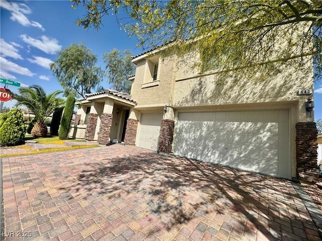 640 House Blend Ln, Henderson, NV 89052 - view of front of house featuring stucco siding, stone siding, a tiled roof, decorative driveway, and an attached garage