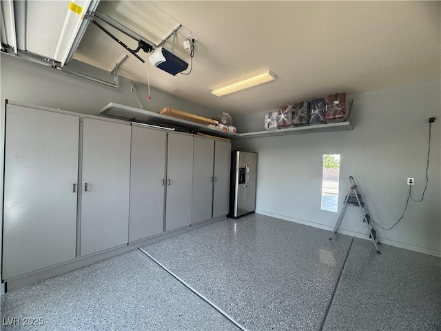 640 House Blend Ln, Henderson, NV 89052 - garage featuring a garage door opener, stainless steel refrigerator with ice dispenser, and baseboards