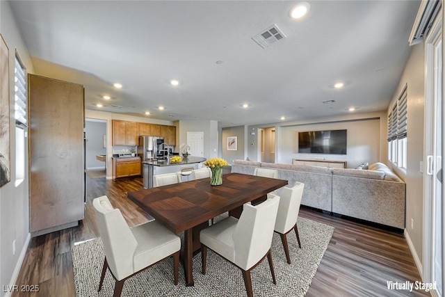 dining space with dark wood-style flooring, recessed lighting, and baseboards