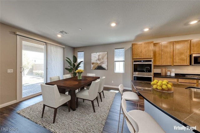 dining area with baseboards, dark wood-type flooring, and recessed lighting