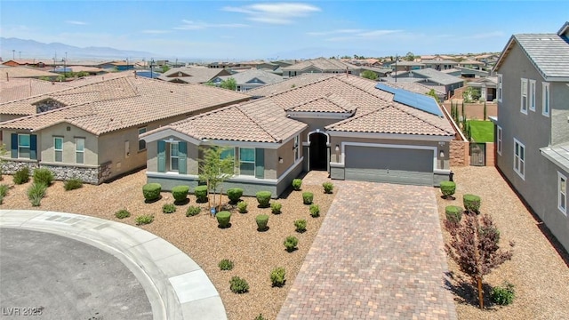 view of front facade featuring an attached garage, stucco siding, a residential view, and a tiled roof