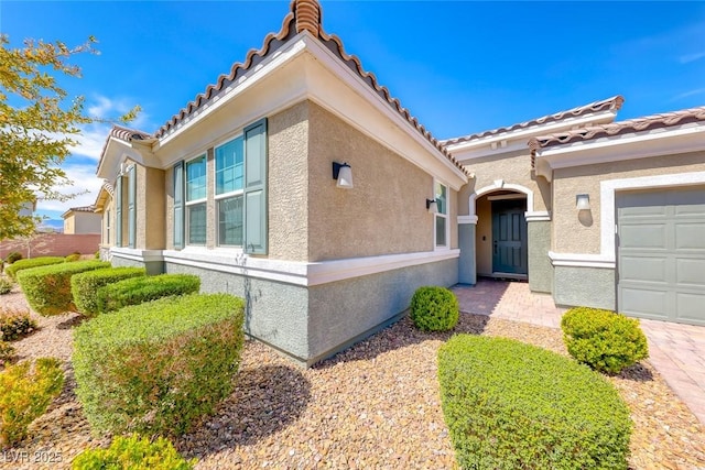property entrance with stucco siding and a tiled roof