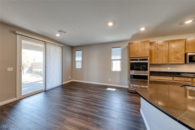 kitchen with stainless steel appliances, dark countertops, baseboards, dark wood-style floors, and recessed lighting