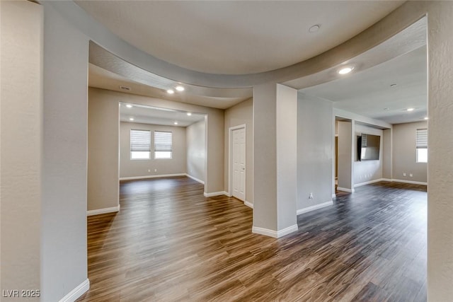 empty room featuring dark wood finished floors, baseboards, and recessed lighting
