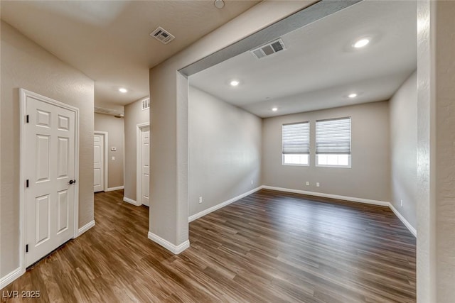 unfurnished room featuring dark wood finished floors, baseboards, and recessed lighting