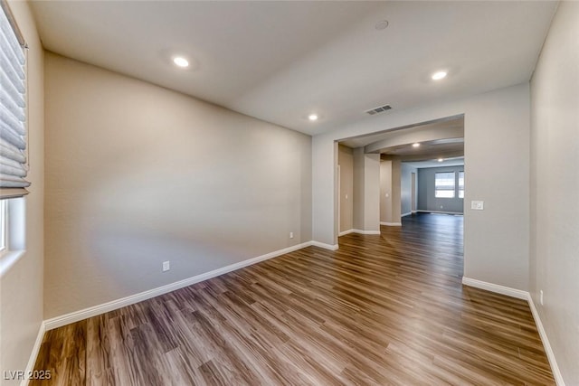 empty room with wood finished floors, baseboards, and recessed lighting