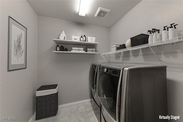 laundry area featuring washer and dryer, baseboards, and a textured ceiling
