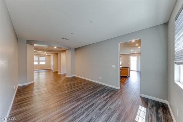 unfurnished living room featuring dark wood-style floors, baseboards, and recessed lighting