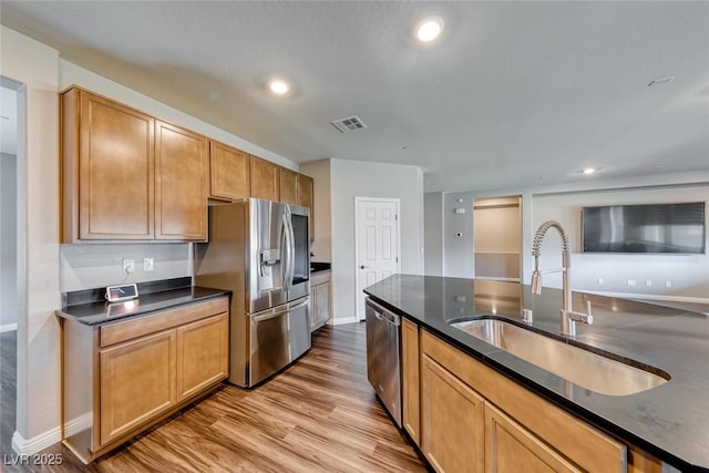 kitchen with appliances with stainless steel finishes, a sink, wood finished floors, baseboards, and recessed lighting