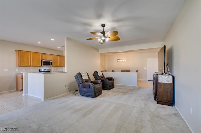 living room featuring ceiling fan, baseboards, recessed lighting, light colored carpet, and light tile patterned floors