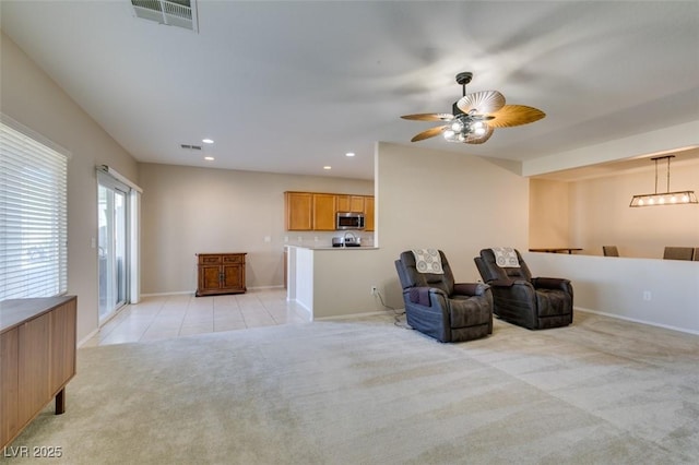 sitting room with light carpet, baseboards, recessed lighting, ceiling fan, and light tile patterned floors