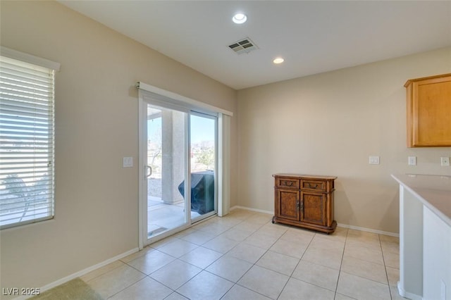 doorway featuring healthy amount of natural light, baseboards, recessed lighting, and light tile patterned floors