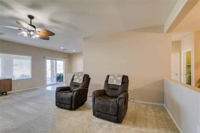sitting room with a ceiling fan, baseboards, and carpet
