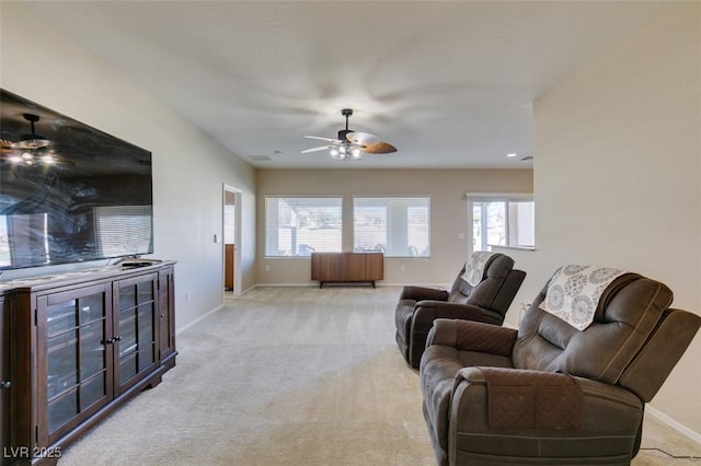 living room featuring ceiling fan, baseboards, and light carpet