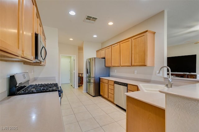 kitchen featuring stainless steel appliances, a sink, light countertops, a peninsula, and light tile patterned floors