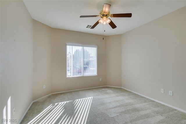 spare room featuring carpet floors, ceiling fan, and baseboards
