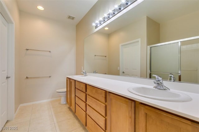 full bathroom with tile patterned floors, double vanity, a shower with door, toilet, and baseboards