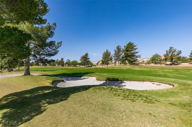 surrounding community with a yard and view of golf course