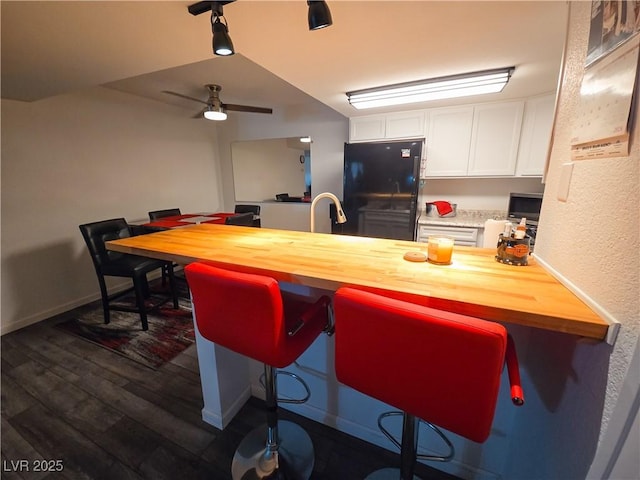 3771 Desert Marina Dr Unit 95, Laughlin, NV 89029 - kitchen featuring freestanding refrigerator, white cabinetry, a ceiling fan, dark wood-style flooring, and wood counters