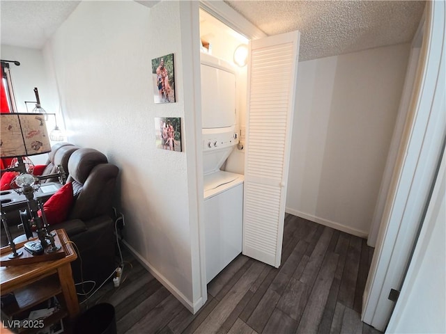 3771 Desert Marina Dr Unit 95, Laughlin, NV 89029 - laundry room with stacked washer and clothes dryer, a textured ceiling, dark wood-type flooring, and baseboards