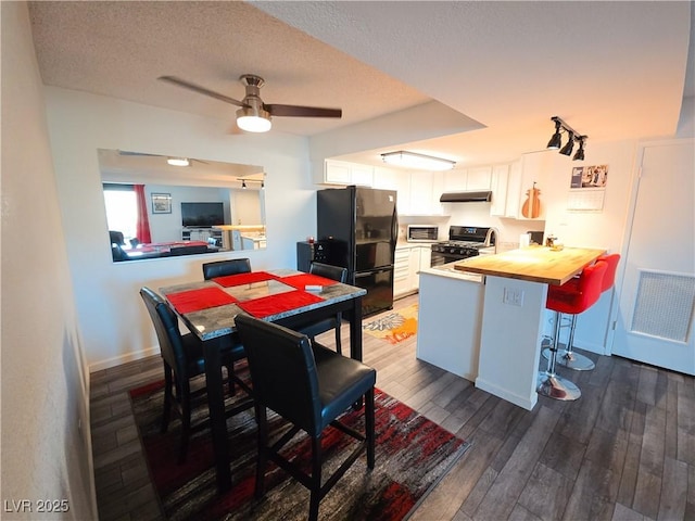 3771 Desert Marina Dr Unit 95, Laughlin, NV 89029 - kitchen featuring black appliances, a peninsula, under cabinet range hood, wooden counters, and white cabinets