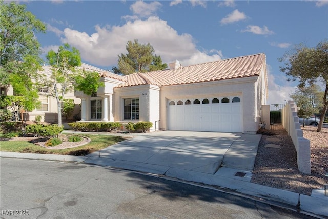 9404 Calico Garden Ave, Las Vegas, NV 89134 - mediterranean / spanish home with a tiled roof, stucco siding, concrete driveway, and an attached garage