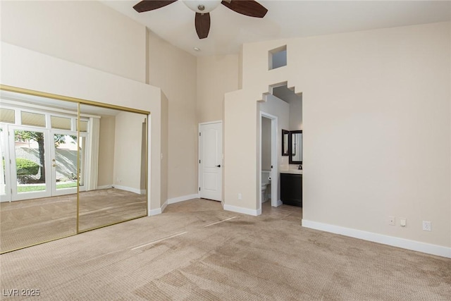 9404 Calico Garden Ave, Las Vegas, NV 89134 - unfurnished bedroom featuring light colored carpet, a high ceiling, baseboards, a closet, and ensuite bathroom