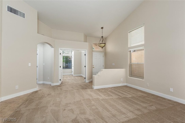 9404 Calico Garden Ave, Las Vegas, NV 89134 - spare room with light colored carpet, arched walkways, baseboards, and lofted ceiling