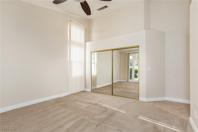 9404 Calico Garden Ave, Las Vegas, NV 89134 - unfurnished bedroom featuring carpet flooring, a closet, ceiling fan, baseboards, and a high ceiling