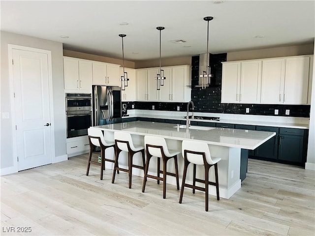 10280 Midnight Meteor Ave, Las Vegas, NV 89166 - kitchen featuring stainless steel appliances, a sink, light wood finished floors, light countertops, and decorative backsplash