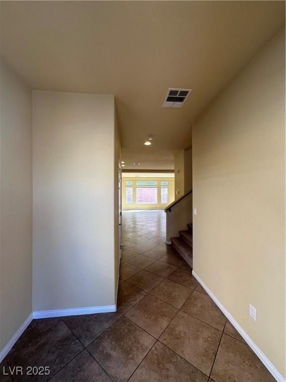 corridor with baseboards, tile patterned flooring, and stairs