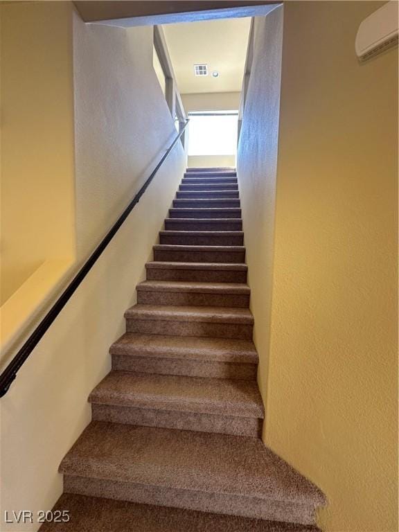 staircase featuring a wall mounted AC