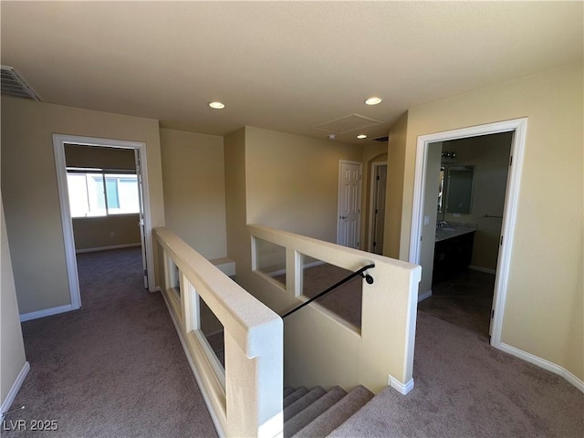hallway featuring an upstairs landing, carpet floors, baseboards, and recessed lighting