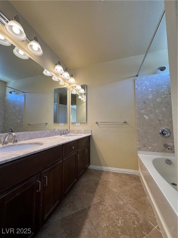 bathroom featuring tile patterned floors, double vanity, baseboards, and shower / tub combination