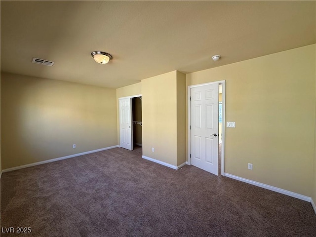 unfurnished bedroom featuring dark carpet, baseboards, and a closet