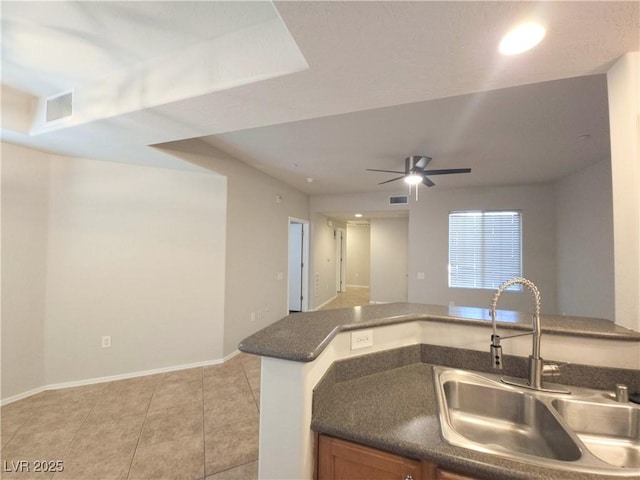 4675 Basilicata Ln Unit 103, North Las Vegas, NV 89084 - kitchen featuring a sink, dark countertops, a ceiling fan, light tile patterned flooring, and baseboards