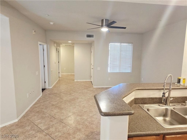 4675 Basilicata Ln Unit 103, North Las Vegas, NV 89084 - kitchen with a sink, a ceiling fan, light tile patterned floors, baseboards, and dark countertops