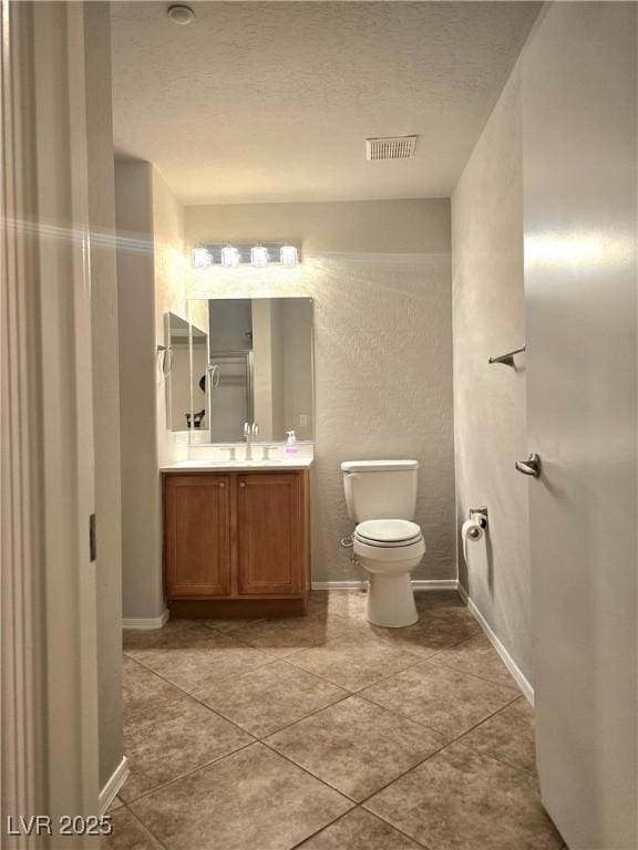 4675 Basilicata Ln Unit 103, North Las Vegas, NV 89084 - bathroom with vanity, toilet, tile patterned floors, a textured ceiling, and baseboards