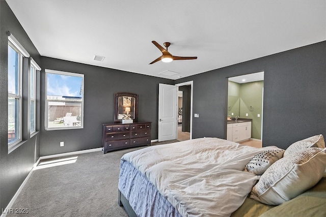 6834 Fallen Rock St, North Las Vegas, NV 89084 - carpeted bedroom featuring baseboards, a sink, ceiling fan, and ensuite bath