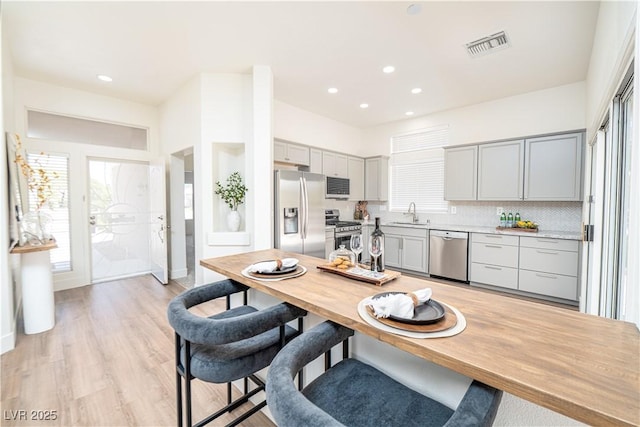 10301 Coal Creek Pl, Las Vegas, NV 89134 - kitchen featuring stainless steel appliances, gray cabinetry, healthy amount of natural light, light wood finished floors, and recessed lighting