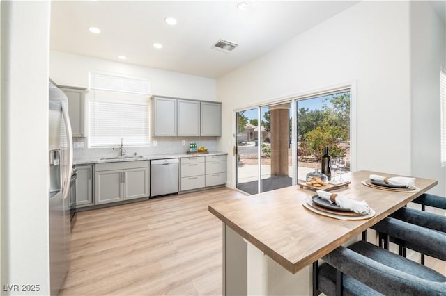10301 Coal Creek Pl, Las Vegas, NV 89134 - kitchen featuring stainless steel appliances, gray cabinets, decorative backsplash, light wood finished floors, and recessed lighting